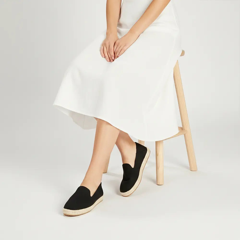 Women's black canvas slip-ons with flat heel support
