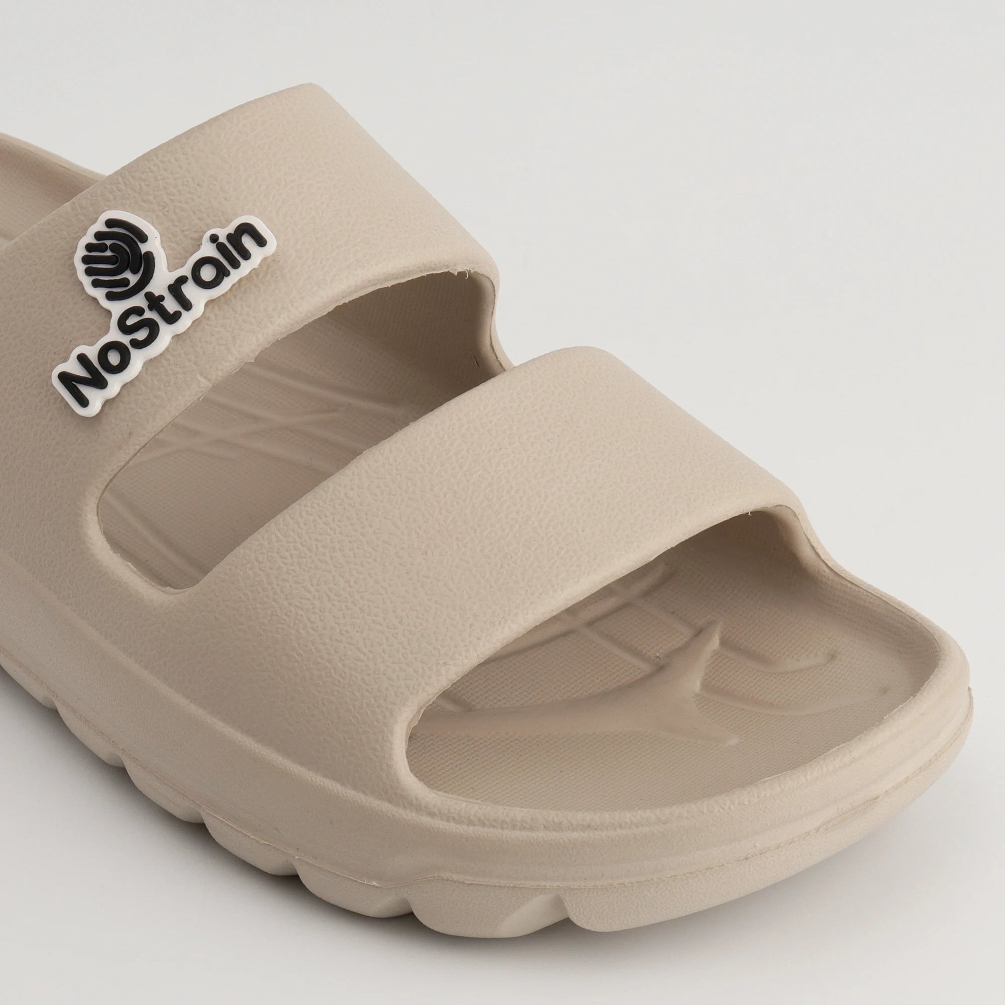 beige EVA sandals on a boardwalk.