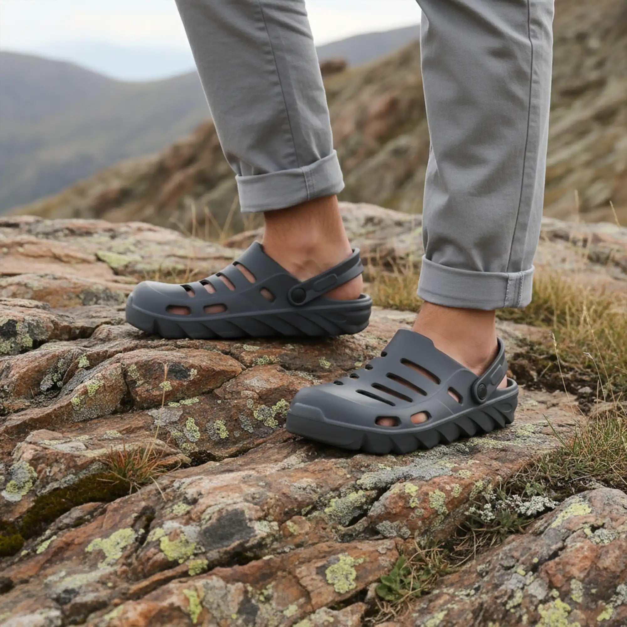 Person wearing NoStrain grey clogs on a rocky mountain trail