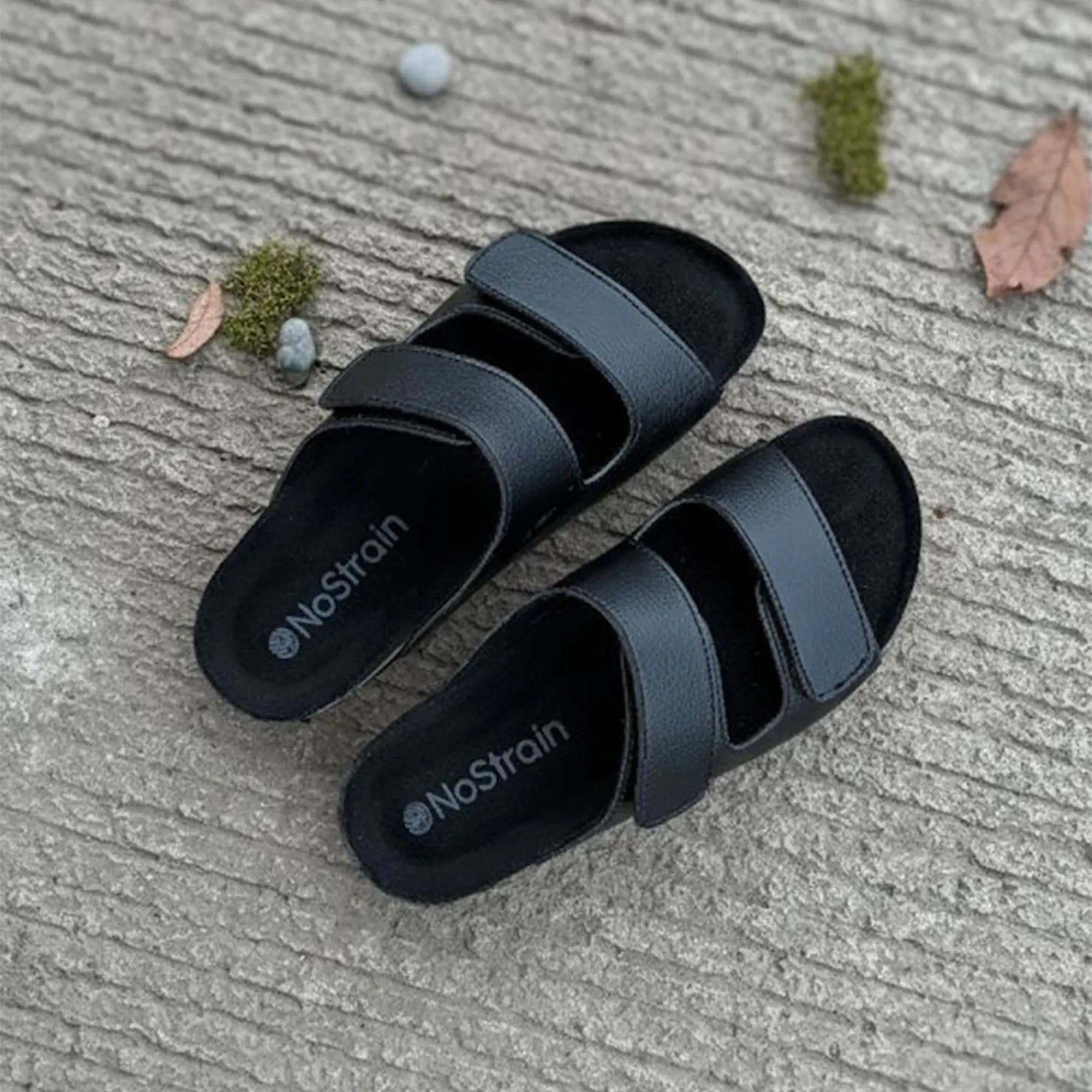 Black sandals with 'NoStrain' branding 